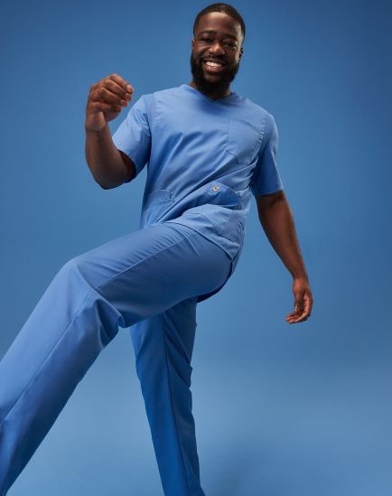 Ein Pfleger trägt ein Outfit in azurblau.